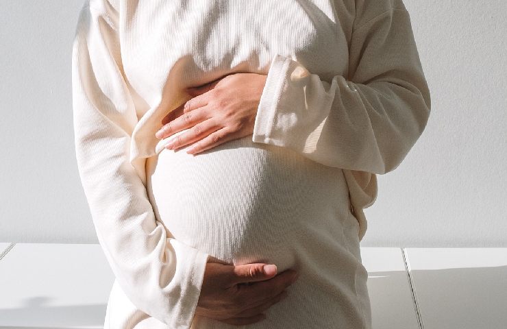 Donna abbraccia la sua pancia in gravidanza