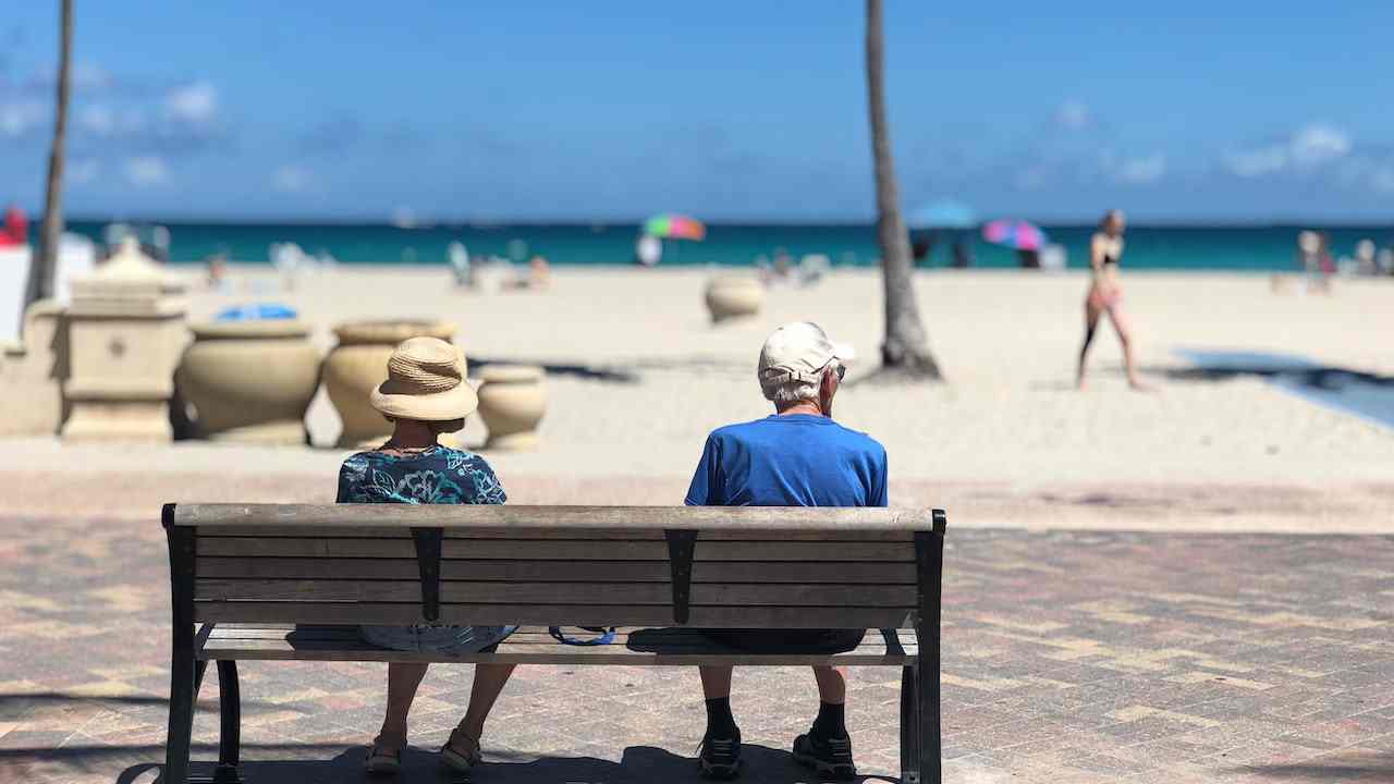 Persone anziane su una panchina in riva al mare