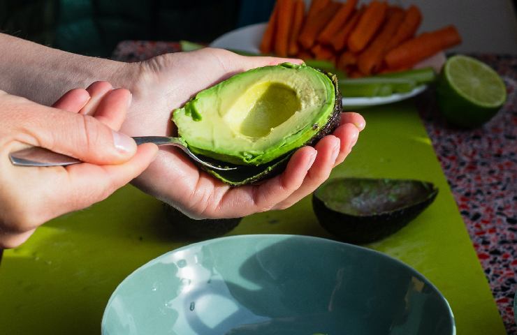 Donna che taglia un avocado