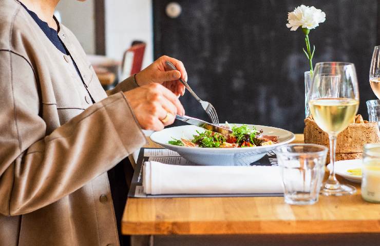 Mani di una ragazza che sta mangiando