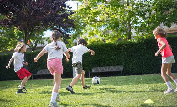 bambini che giocano a palla in giardino