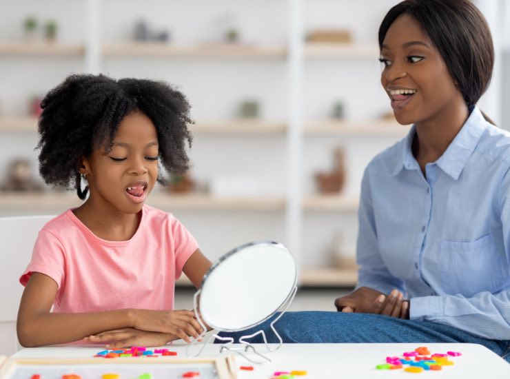 Una bambina si guarda allo specchio per pronunciare parole