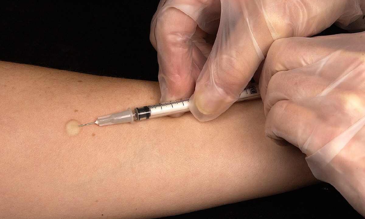 Un medico intento a somministrare un vaccino