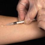 Un medico intento a somministrare un vaccino