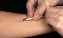 Un medico intento a somministrare un vaccino